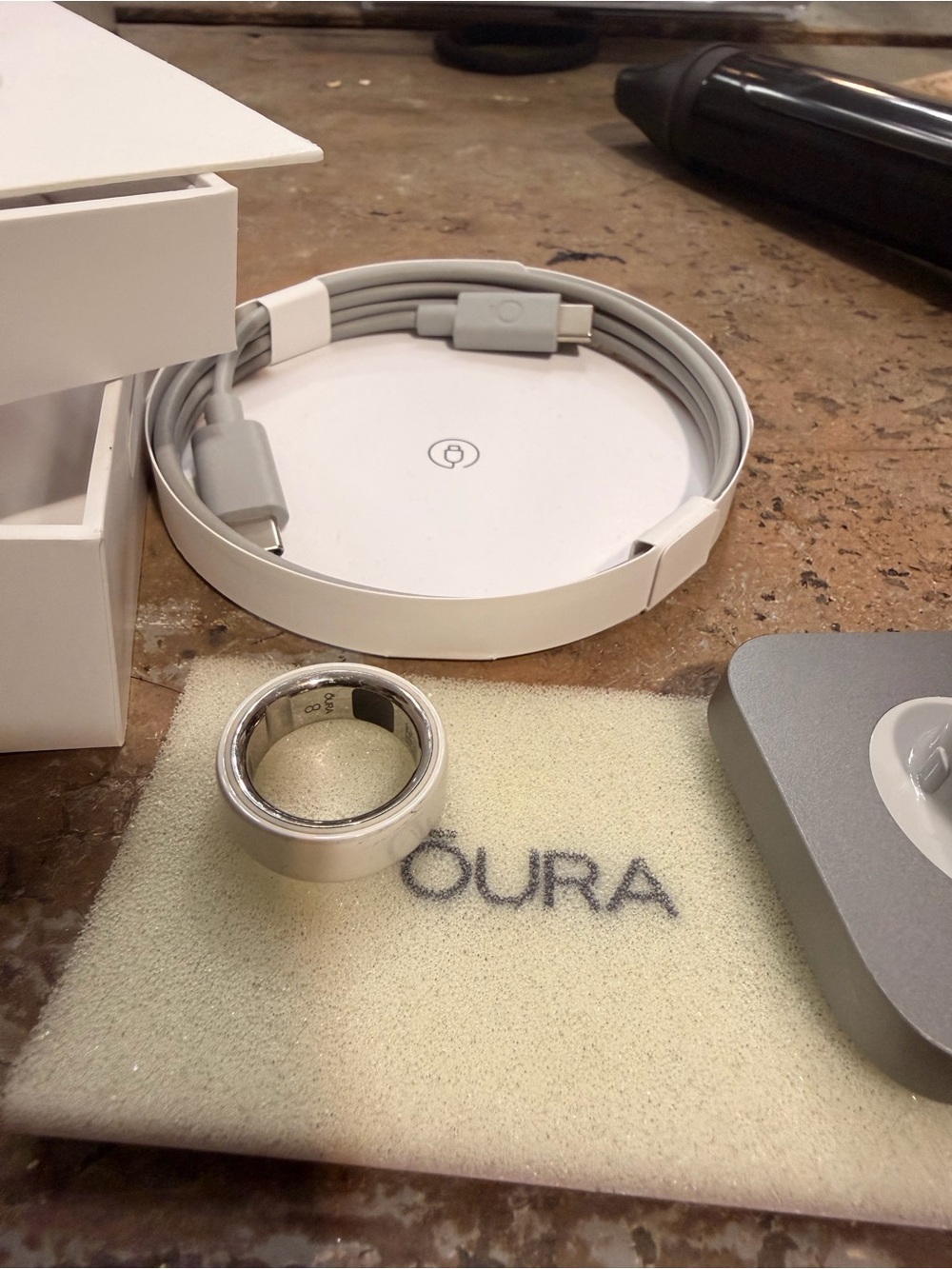Oura Silver Smart Ring with White Charging Pad and Gray Cable